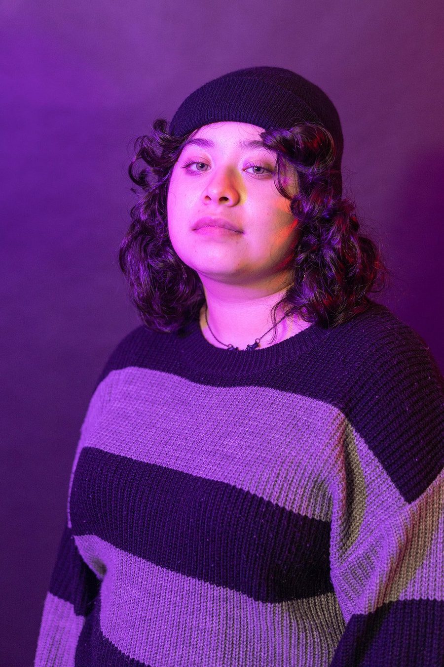 Portrait of a student in a striped sweater under violet light