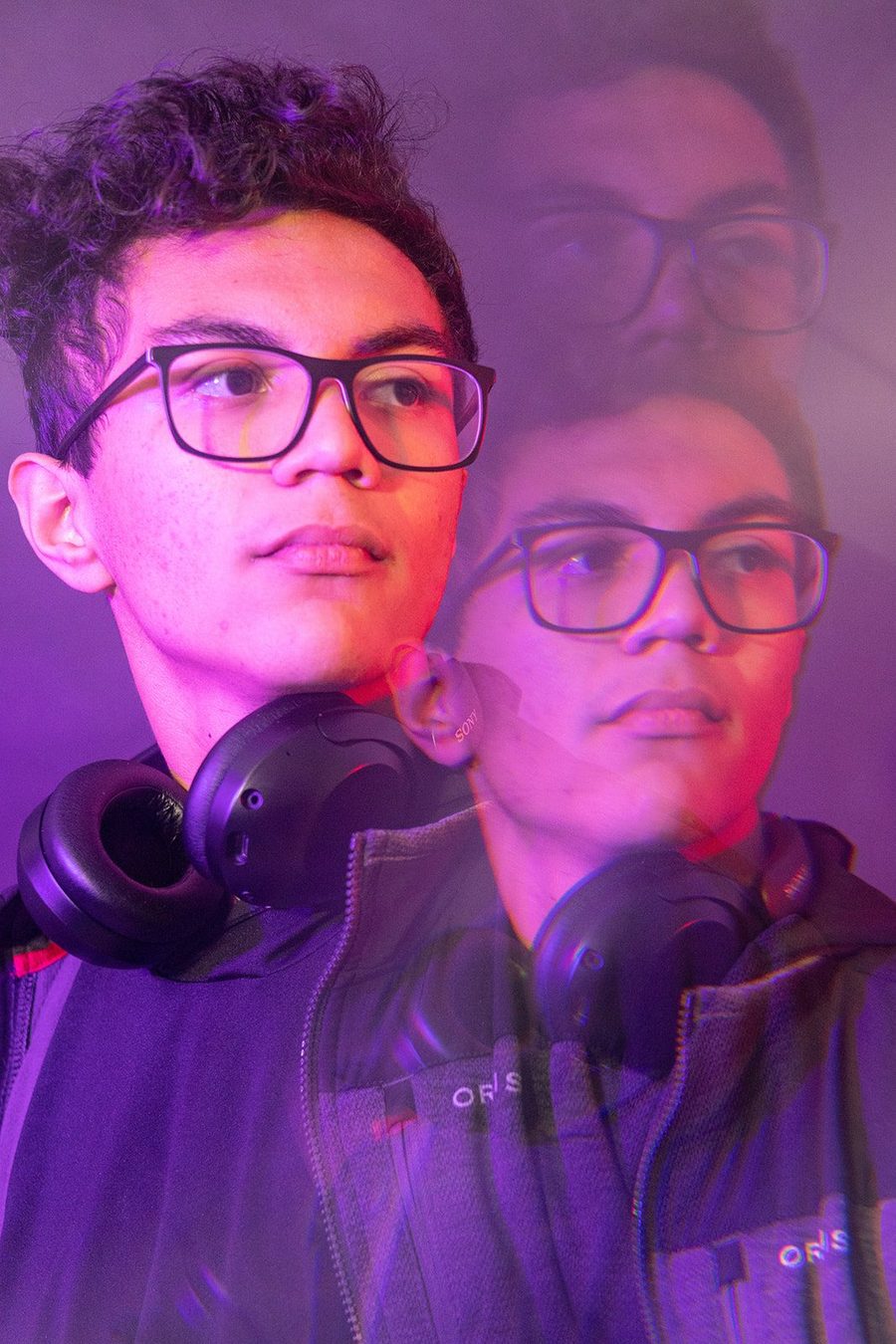 Multiple exposure portrait of a student with glasses in violet and red